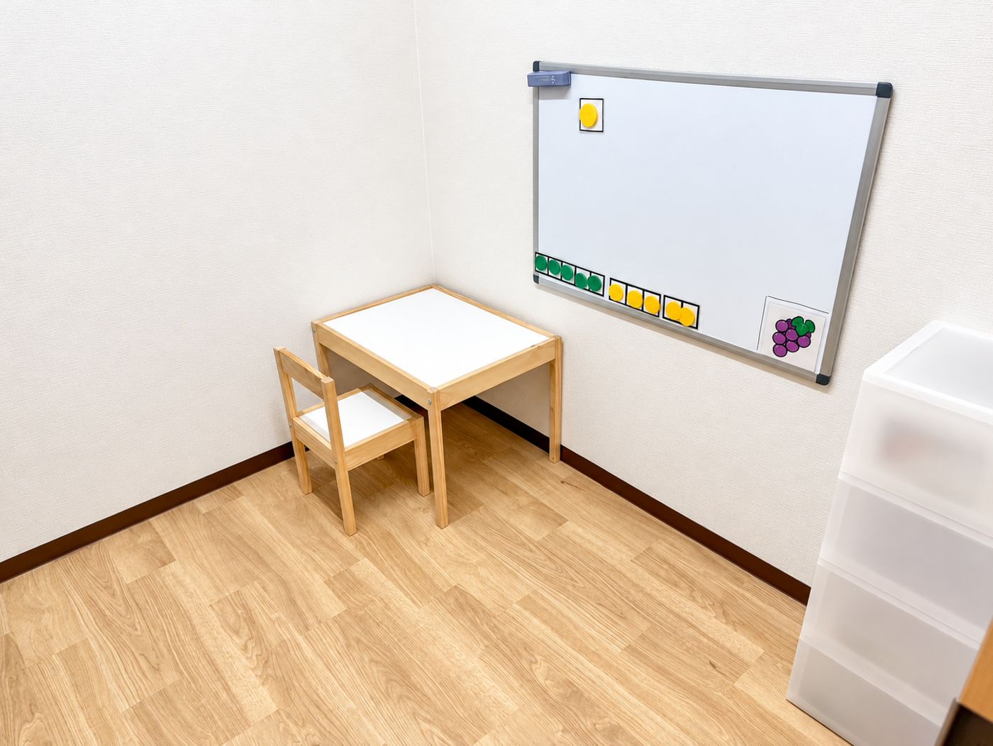 木の机といすとホワイトボードがある、ぶどうのお部屋
