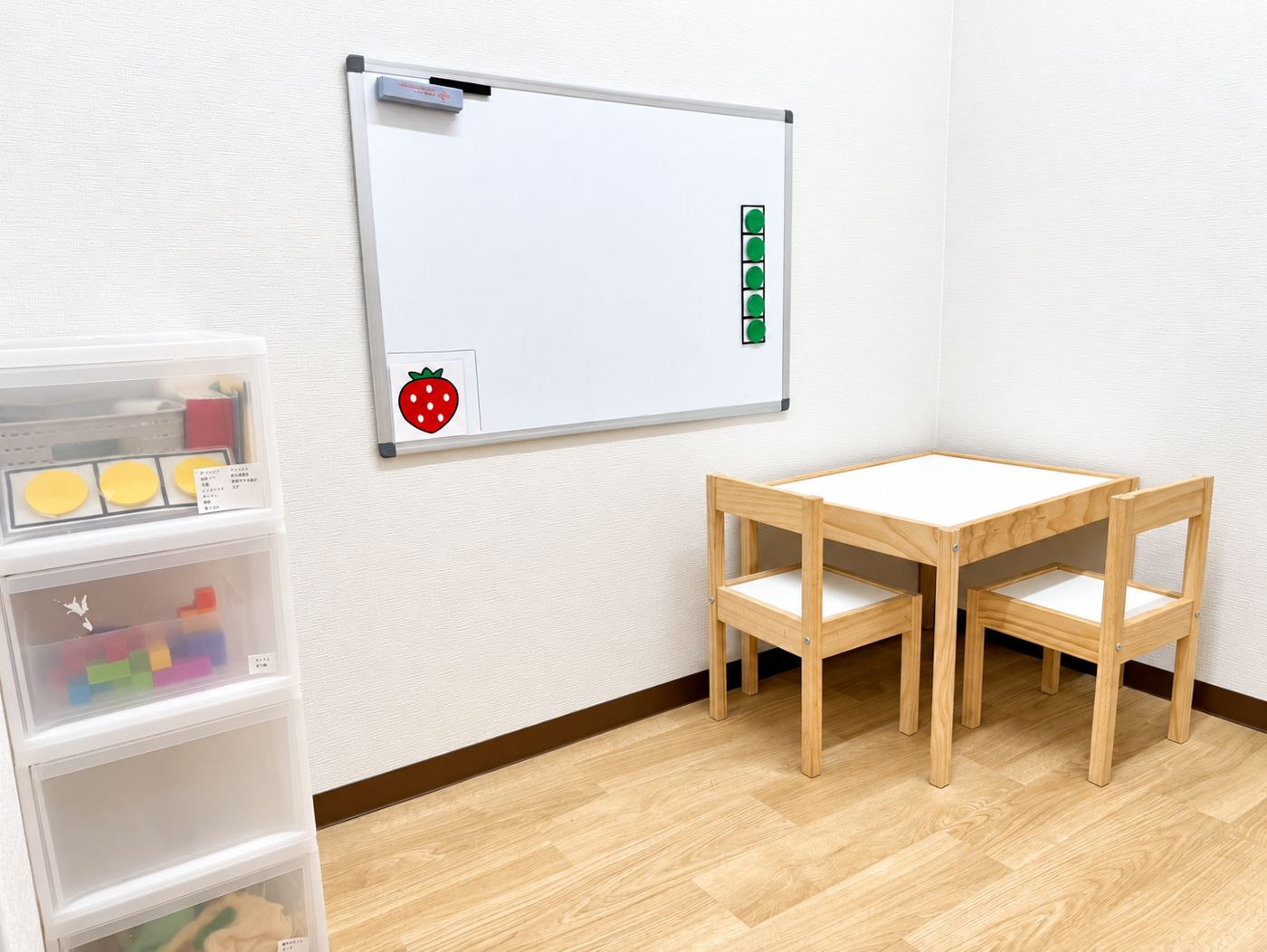 小さな机といすとホワイトボードがある、いちごのお部屋